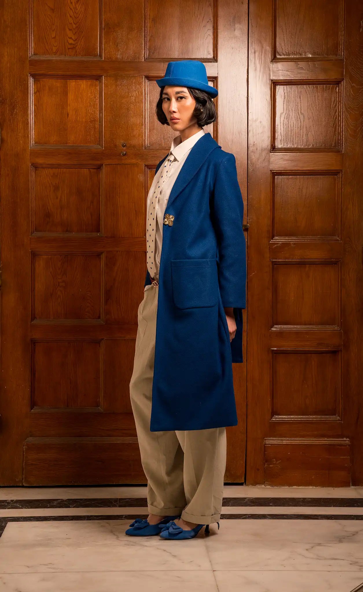 Model wearing a bleu royal coat with a deep blue tone and a strong sophisticated silhouette