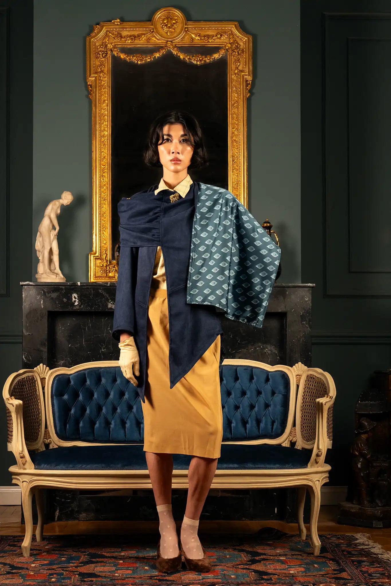 Model wearing a dark blue empress cape featuring deep blue tones and a flowing sophisticated silhouette